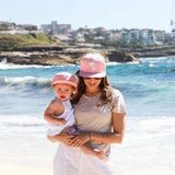 Mum and daughter wearing matching pink palm snapback hats. Cubs & Co. Australia