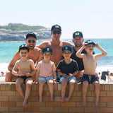 Boys and men wearing matching personalised black baseball caps with their initials. Cubs & Co. Australia.