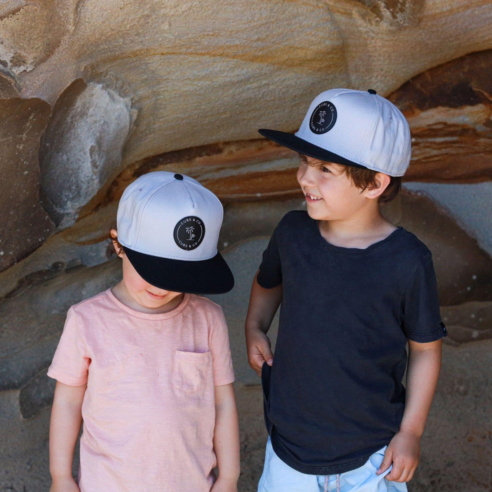 brothers wearing matching grey and black snapback sun hats. cubs & co. Australia