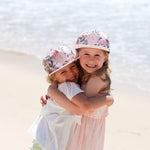 Girls wearing matching pink floral snapback hats. Cubs & Co. Australia.