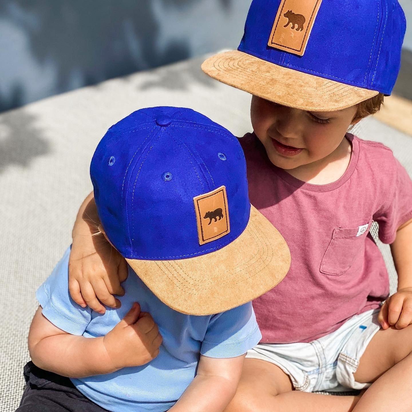 Boys wearing matching suede snapback hats. Cubs & co. Australia