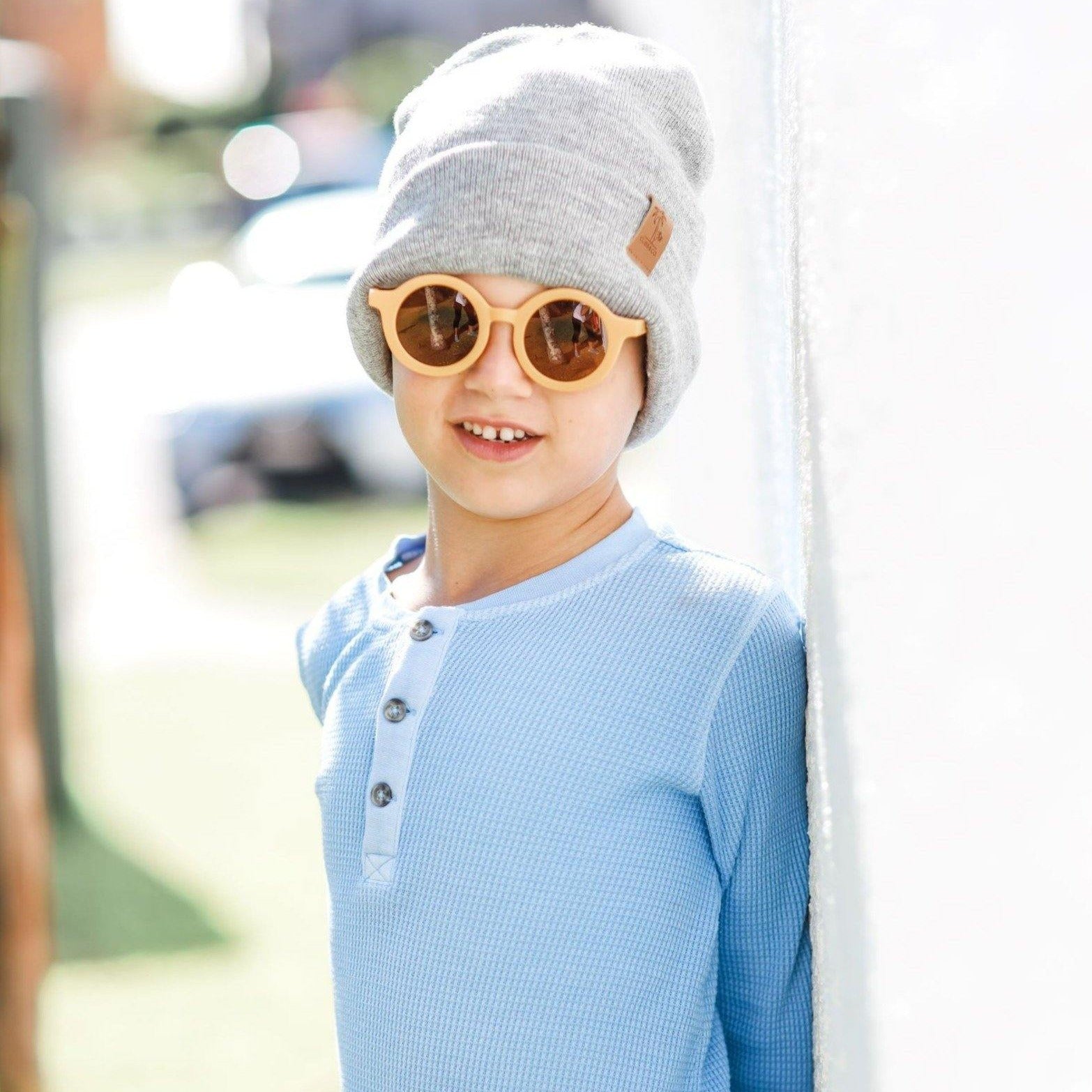 Boy wearing kids yellow butterscotch sunglasses with UV protection. Cubs & Co. Australia