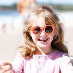 Girl wearing kids orange terracotta sunglasses with UV protection. Cubs & Co. Australia