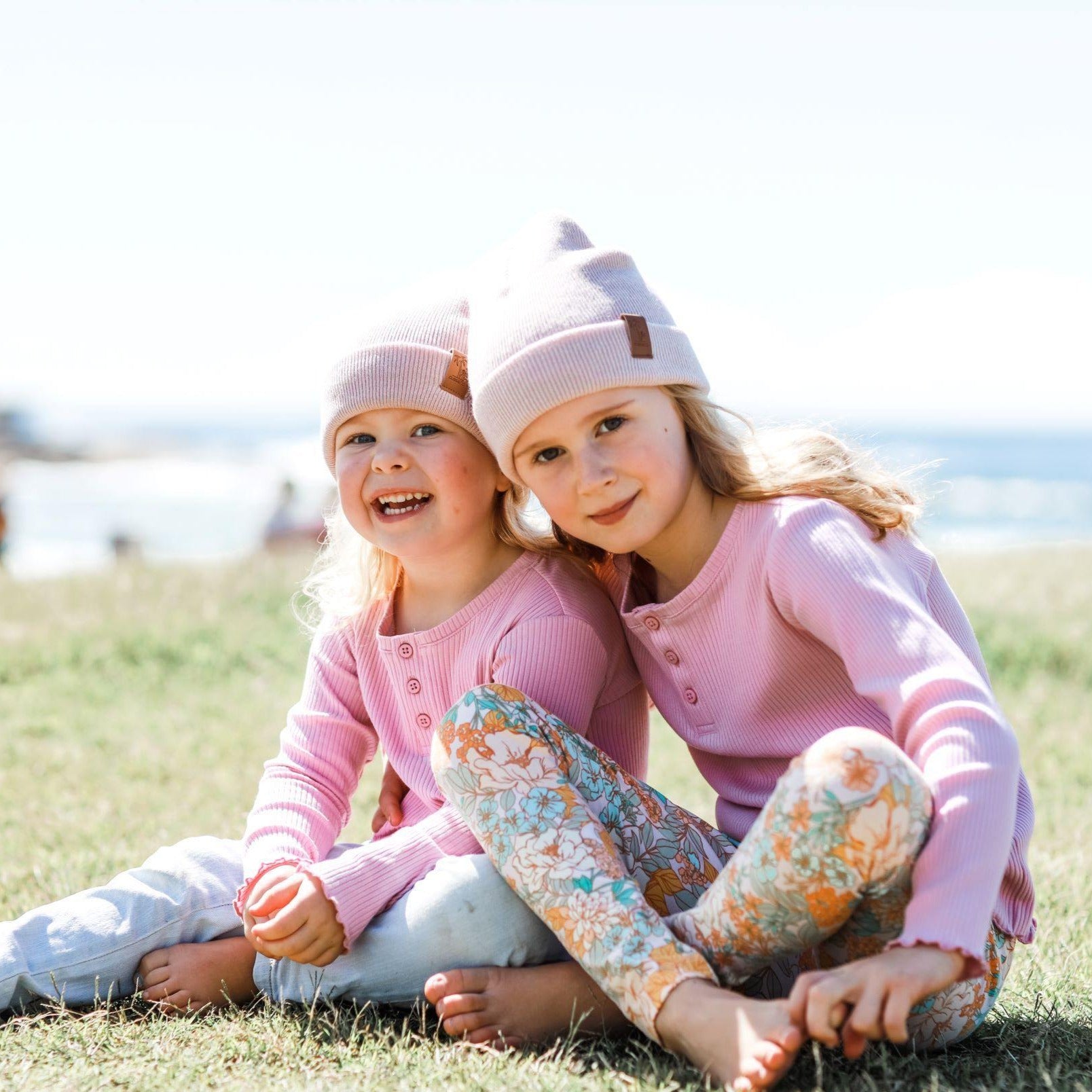 Sisters wearing matching pink winter beanies. Cubs and Co. Australia